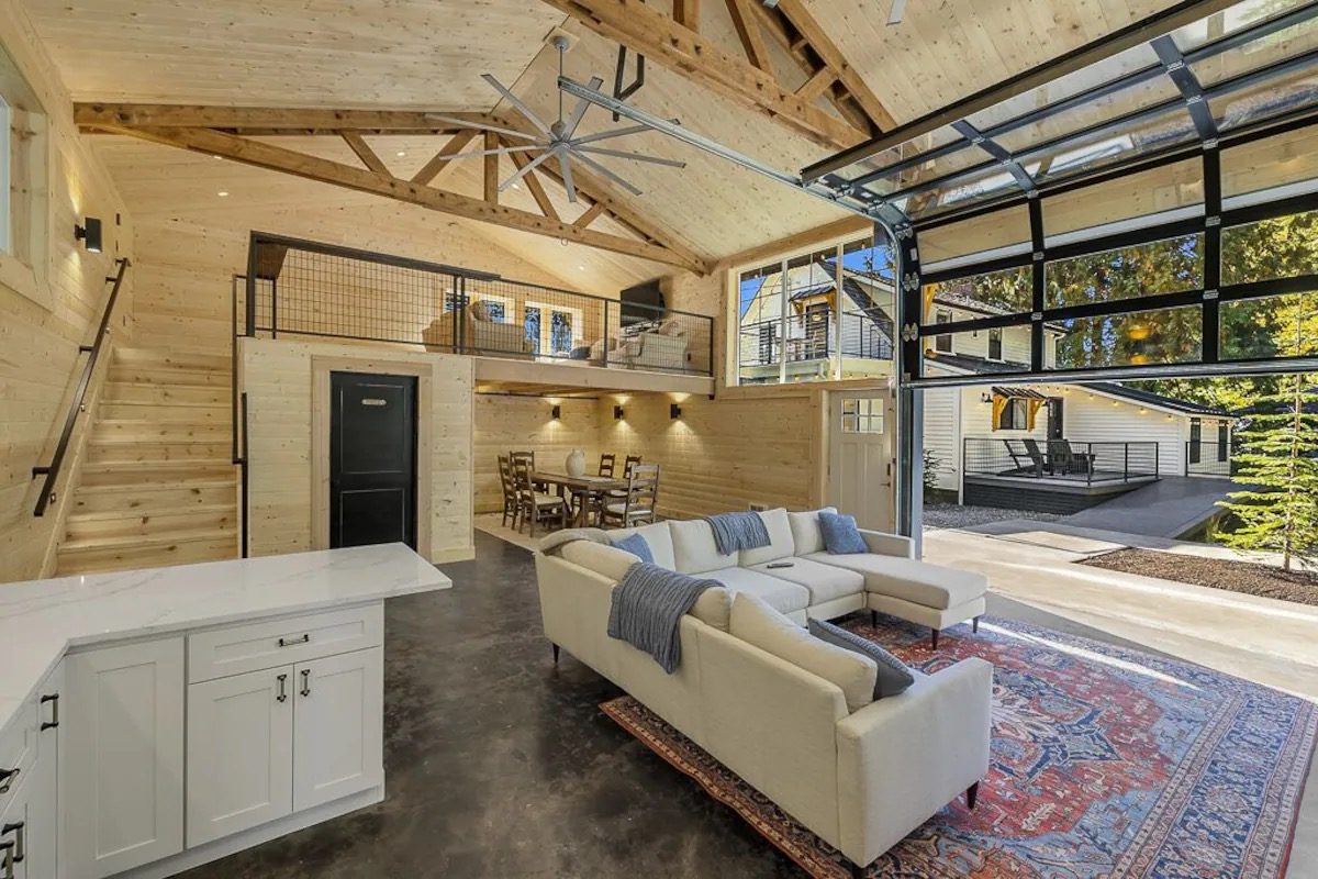 Great room with exposed trusses, loft and glass garage door