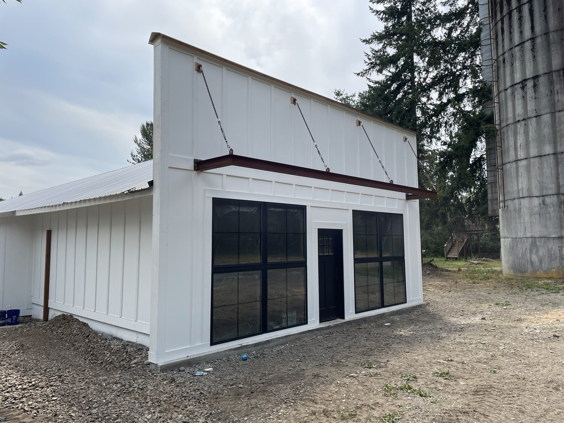 Board-and-batten shop building with steel awning