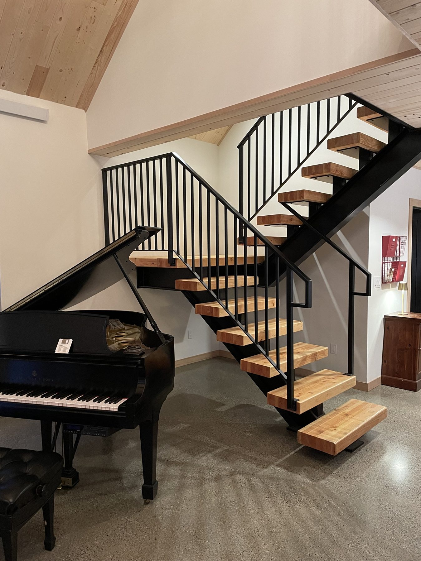 Steel center-stringer stair with timber treads and black picket railing